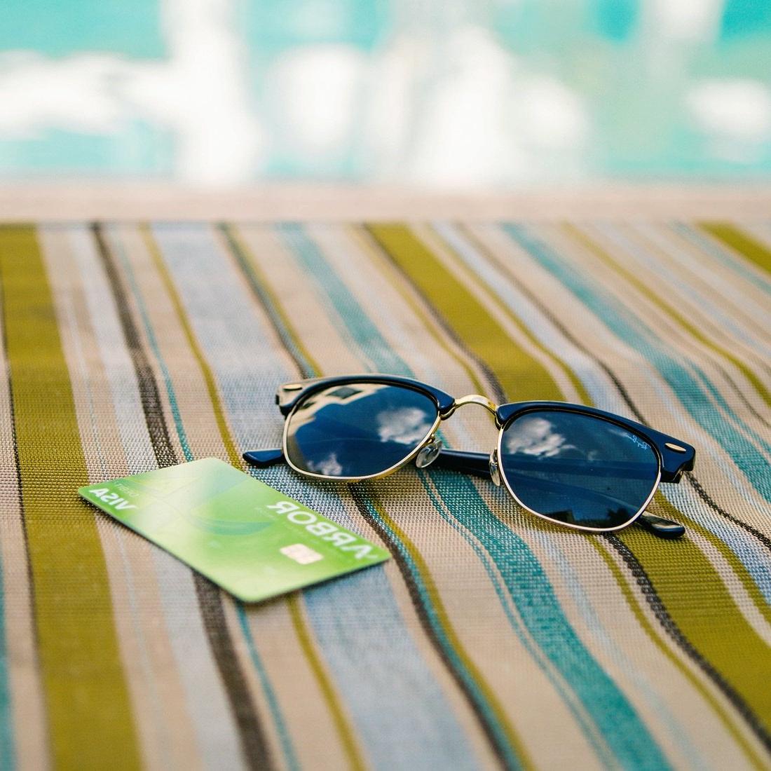 Sunglasses and an Arbor debit card on a beach towel.